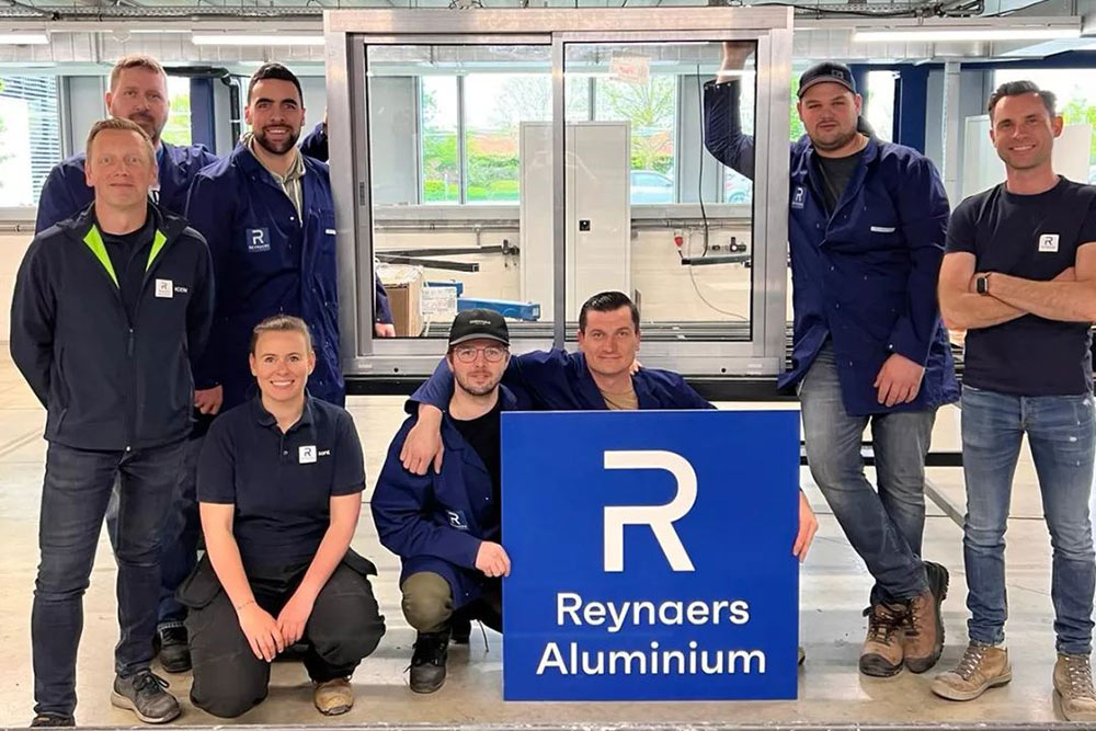Grens team photo with Reynaers Aluminum sign