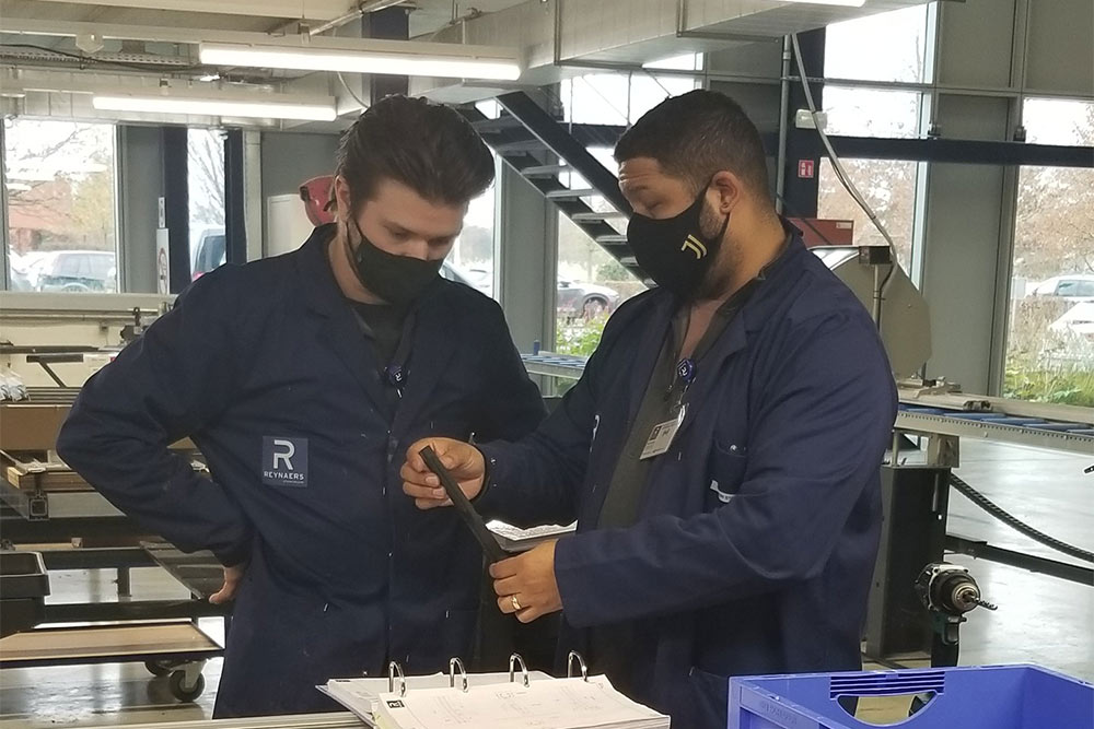 two men wearing masks working in Grens’ manufacturing facility